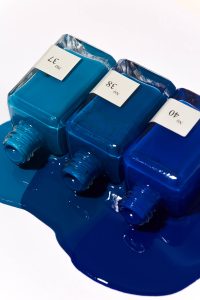 3 sundays studio blue nail polish bottles spilling over on table