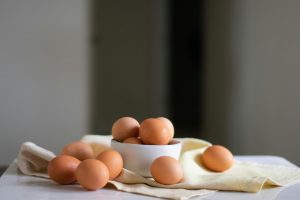brown eggs on a counter top and in a white bowl