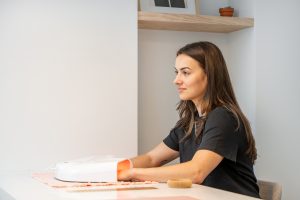woman using drying light on nails at manicure table