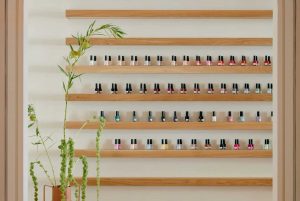 floating wooden shelves on a white wall with sundays studio nail polishes of a variety of colors
