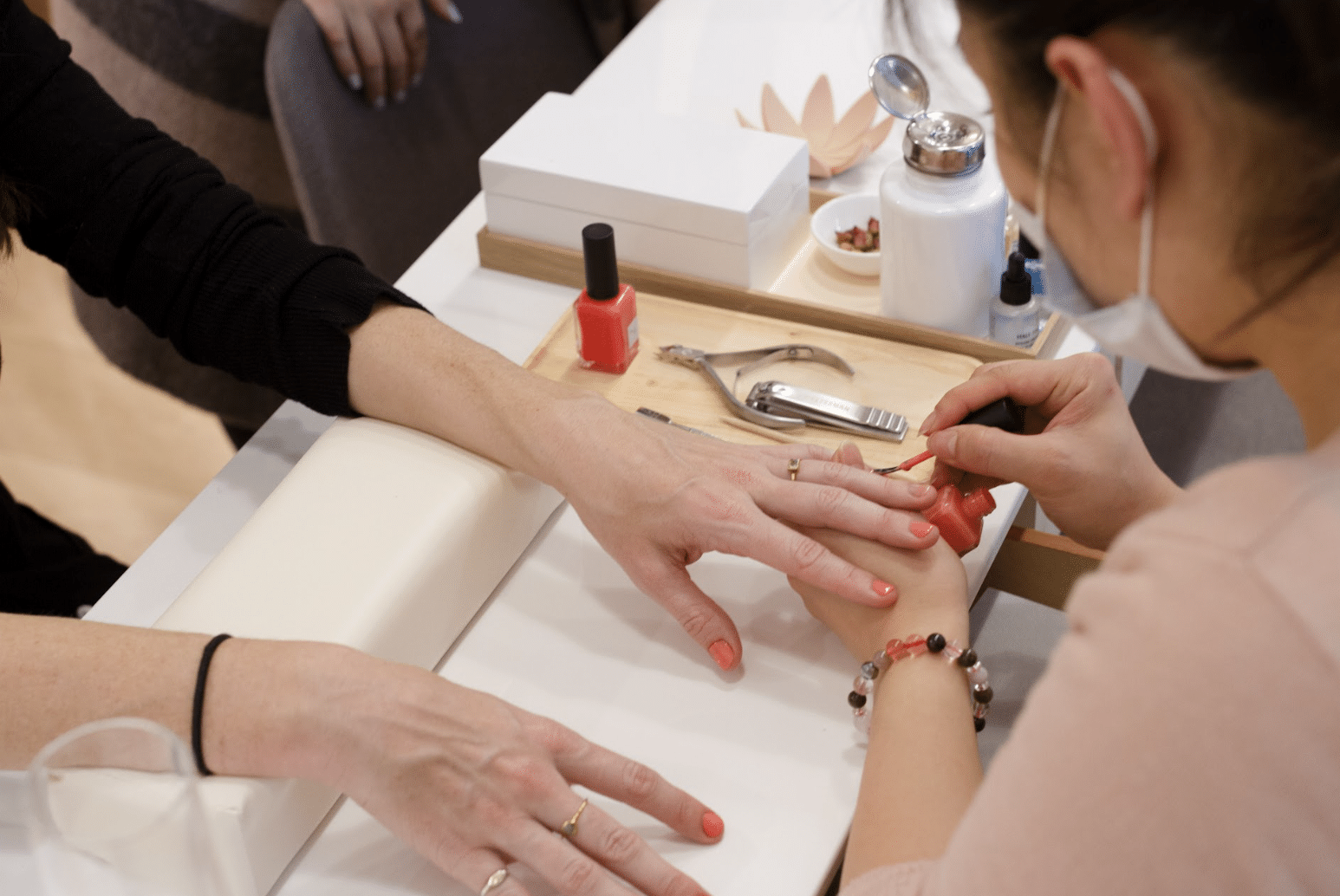 woman getting her nails done with hot pink polish