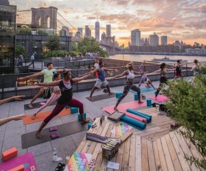 group of women doing yoga with view of New York City