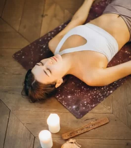 woman meditating with candles