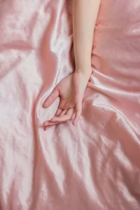 Hand posing on pink sheet