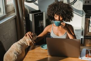 woman drinking coffee and petting her dog