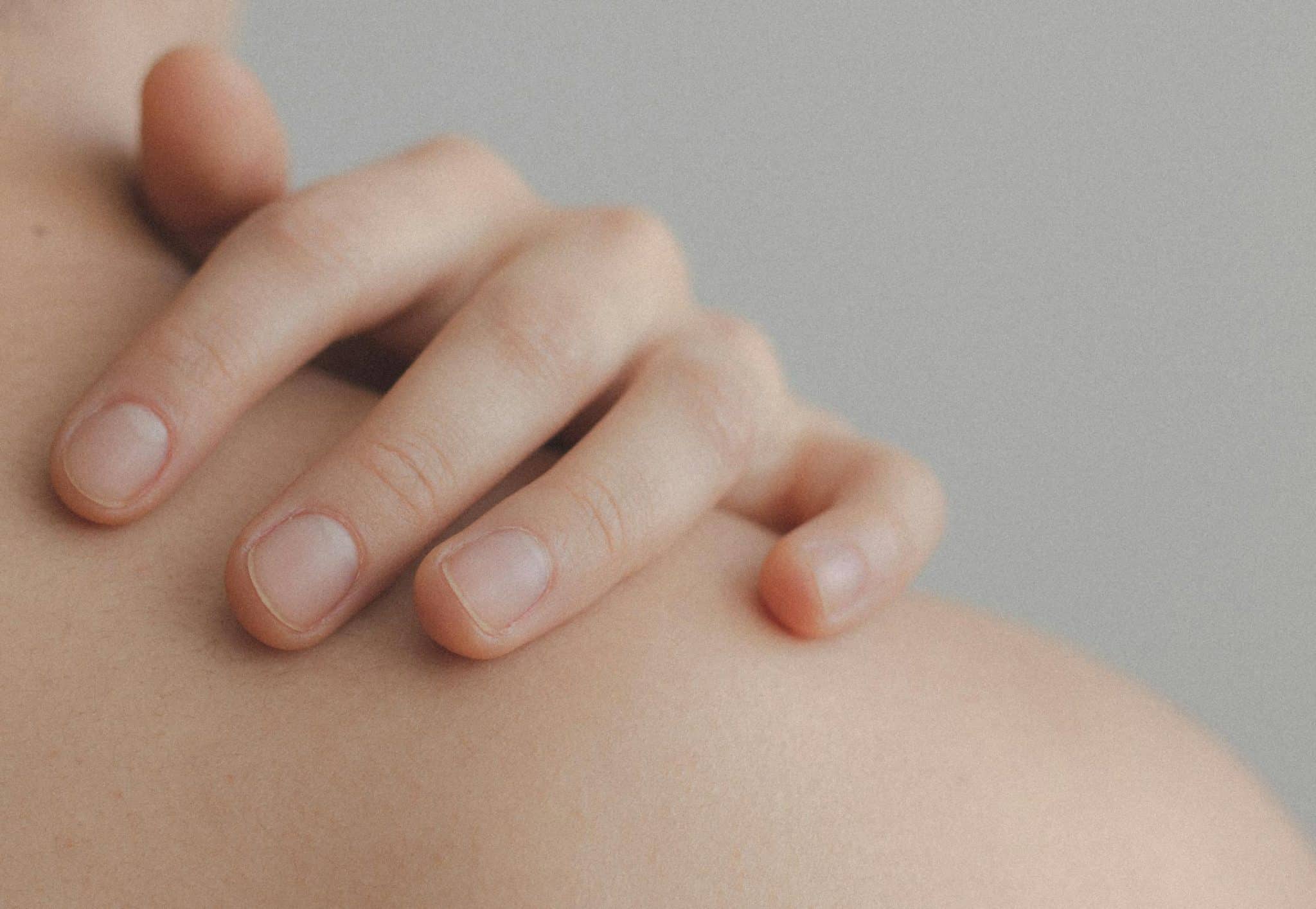 clean, bare nails resting on woman's shoulder
