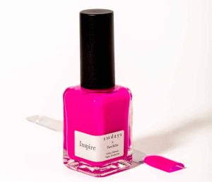 A bottle of sundays x Tara Stiles hot pink nail polish in front of a white background.