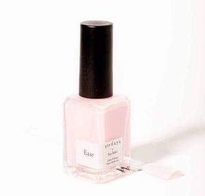 A bottle of sundays x Tara Stiles sheer pink nail polish in front of a white background.