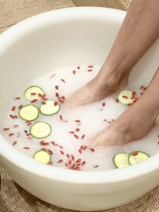 Feet soaking in rose anti aging foot bath while getting a pedicure