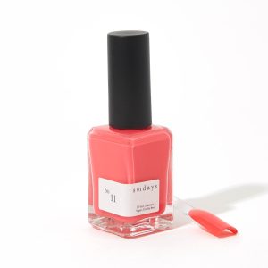 A bottle of sundays No.11 coral pink nail polish in front of a white background.