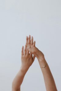 Womans arms intertwined in front of white background