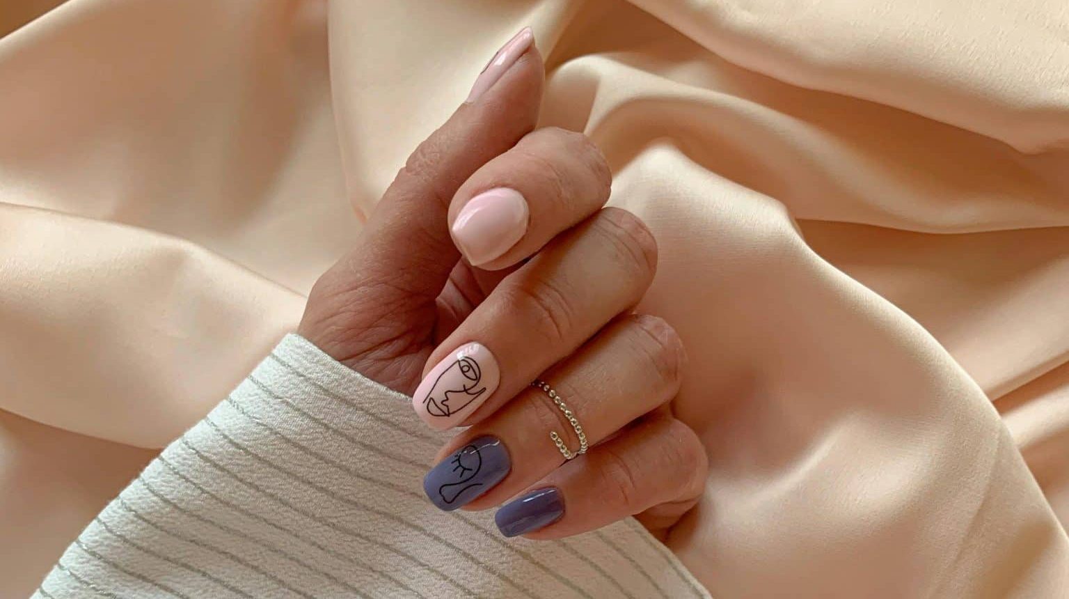 Close up of a woman's hand with press on nails with a design