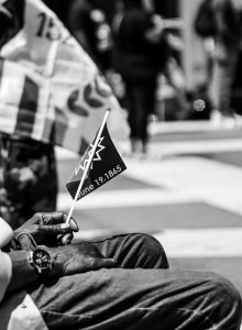 Photo of man sitting down holding June 19th flag