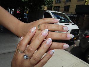 Close up of a woman's nails with french tip manicure and lemon nail art