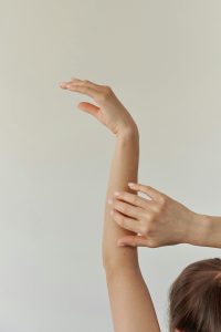woman's hands with right hand on left forearm